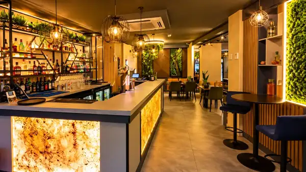 The Appayon bar and dining room with a backlit counter, navy stools and greenery